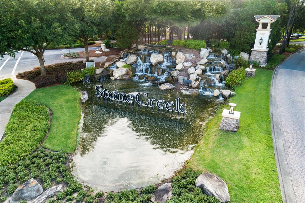An aerial view shows a stone waterfall feature with a Stone Creek sign in a pond — 6606 SW 91ST CIRCLE UNIT 6606, OCALA, FL