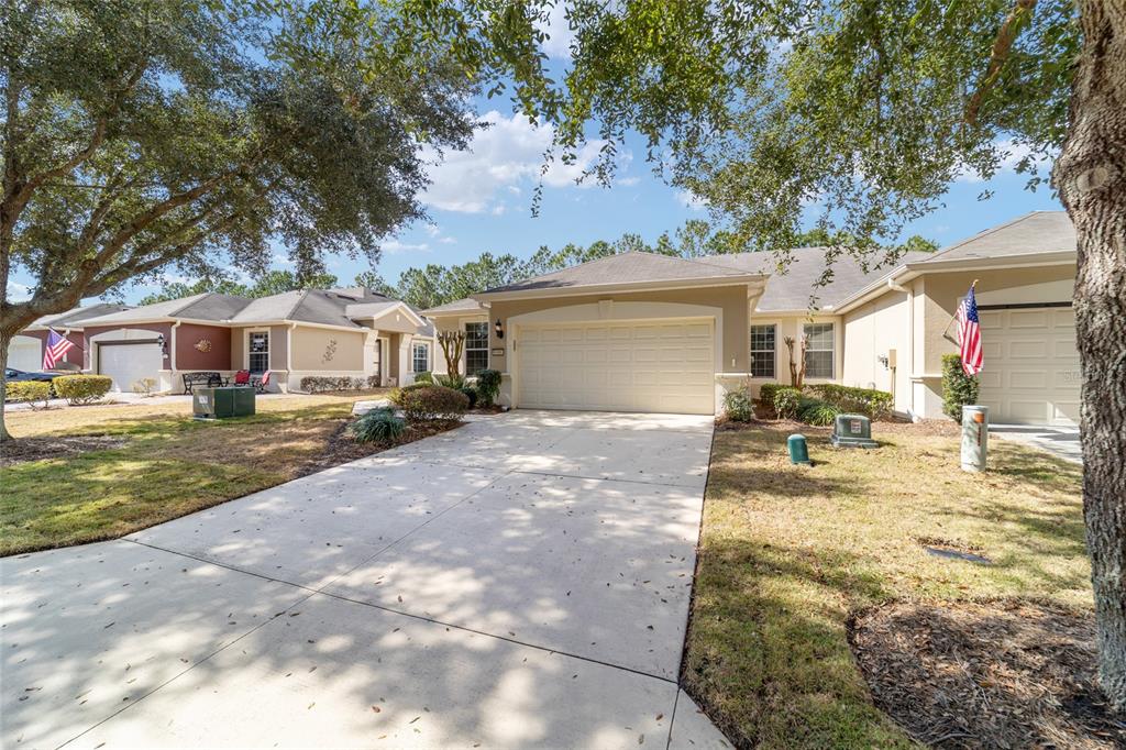 A view of the concrete driveways and front facades of two suburban single-story homes — 6606 SW 91ST CIRCLE UNIT 6606, OCALA, FL