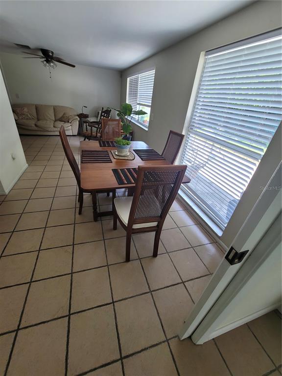 A dining area features a wooden table with four chairs on a tiled floor — 9826 LEHIGH DRIVE, PORT RICHEY, FL