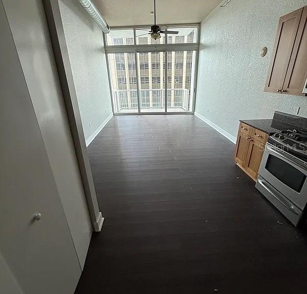 A kitchen area with dark wood flooring leads to a balcony with city views — 150 E ROBINSON STREET UNIT 627, ORLANDO, FL