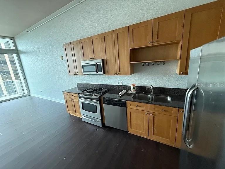 A kitchen features light wood cabinets, stainless steel appliances, and dark countertops — 150 E ROBINSON STREET UNIT 627, ORLANDO, FL