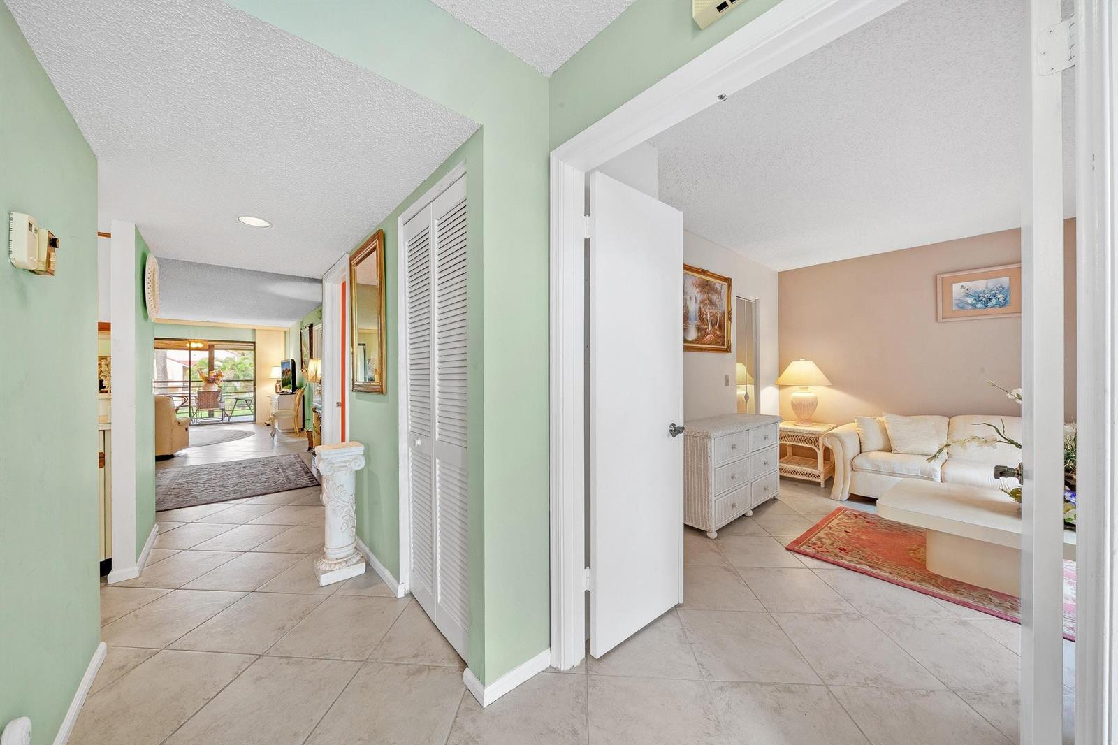 A view from a tiled hallway into a living room with light walls and furniture — 5306 Cedar Lake Drive # 203, Boynton Beach FL 33437, BOYNTON BEACH, FL