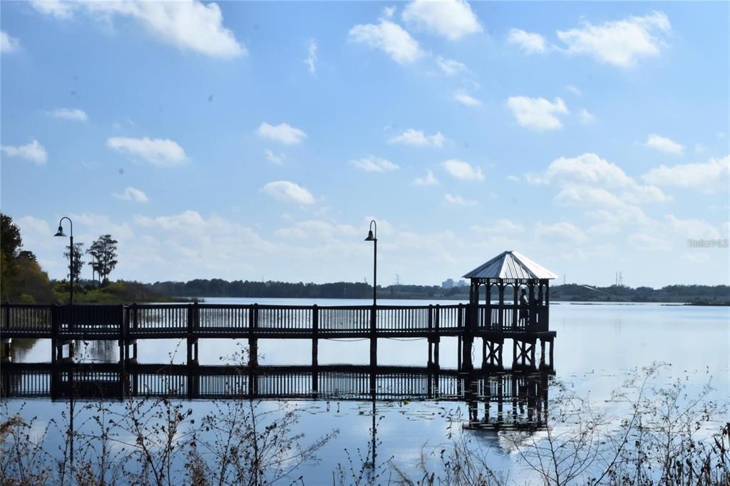 A wooden pier with a gazebo extends over a calm lake under a blue sky — 3396 PARKCHESTER SQUARE BOULEVARD UNIT 104, ORLANDO, FL