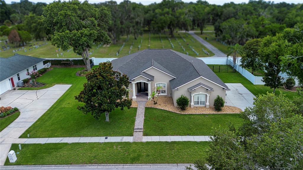 An aerial view shows a single-story house with a gray roof and a paved driveway — 905 SQUARE LAKE DRIVE, BARTOW, FL