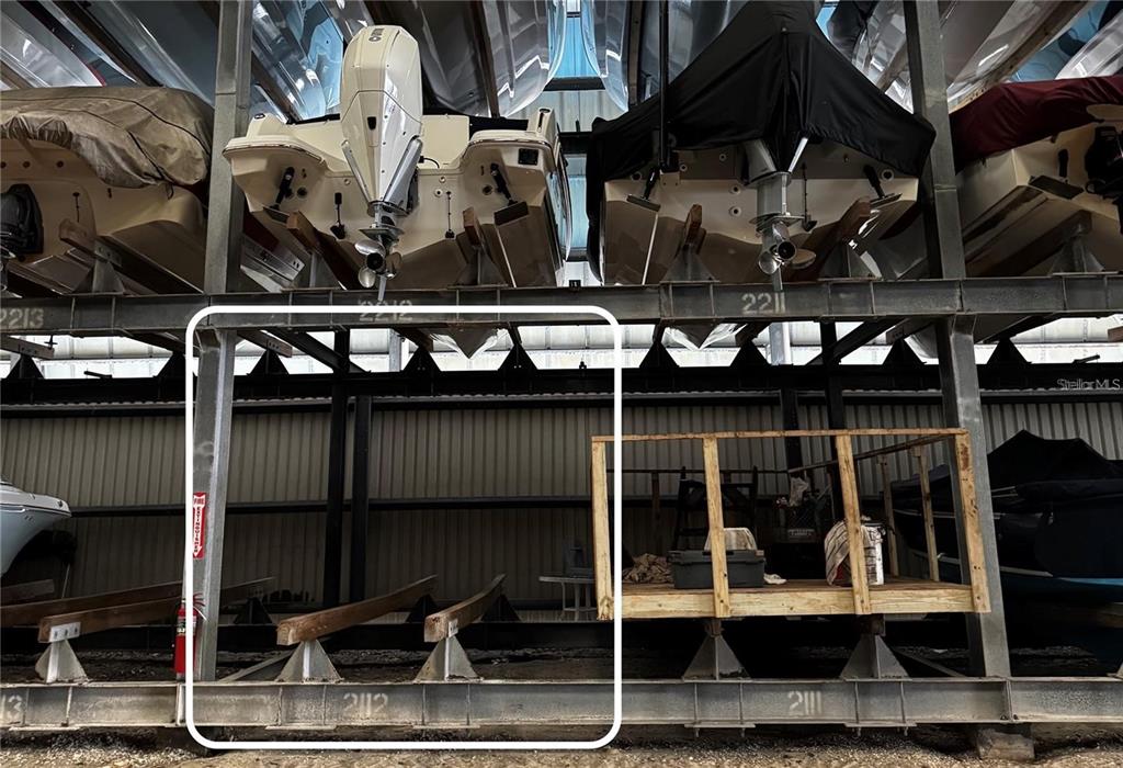 A boat storage facility features multiple levels of metal racks holding various watercraft — 408 GULF OF MEXICO DRIVE UNIT 2112, LONGBOAT KEY, FL
