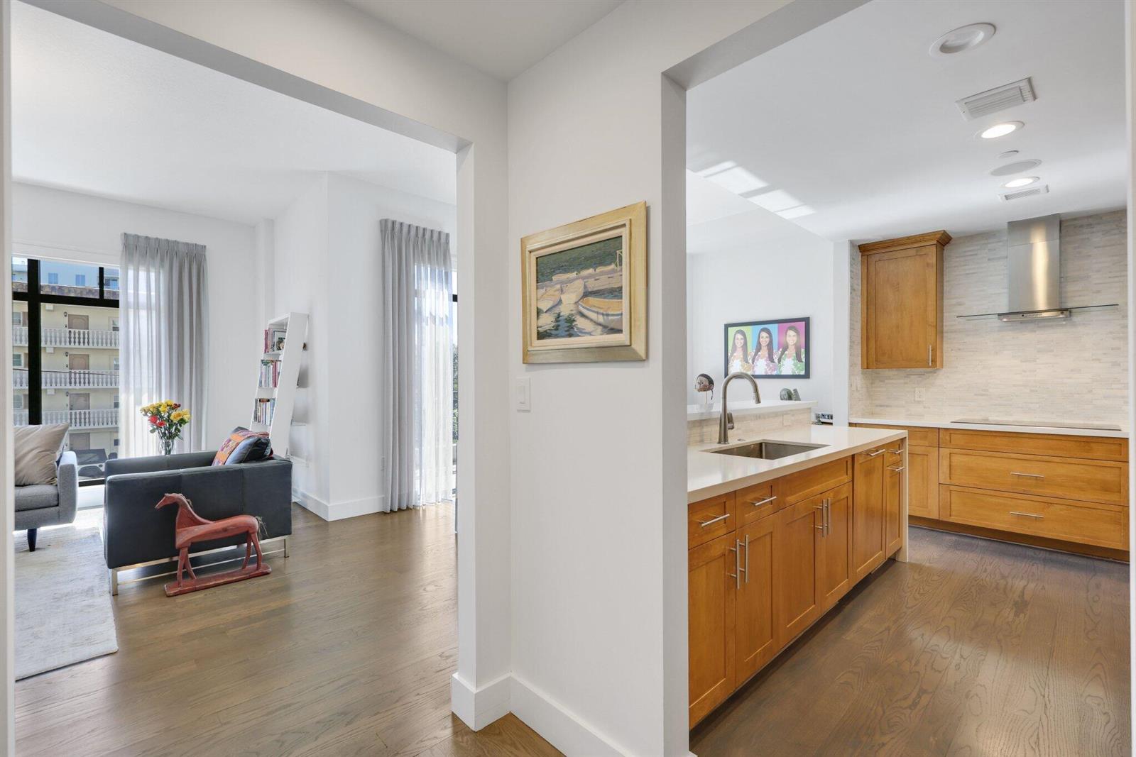 A view from a hallway into a living room and a kitchen with wood cabinets — 200 E Palmetto Park Road # 7, Boca Raton FL 33432, BOCA RATON, FL