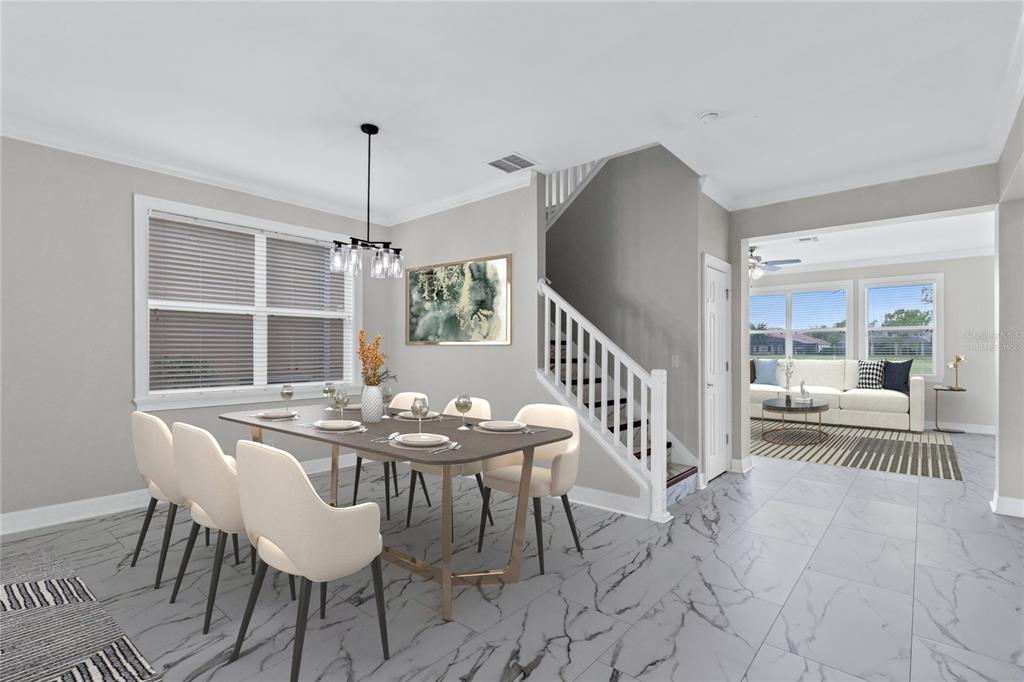 A dining area with a table and chairs sits next to a staircase and living room — 10408 CHORLTON CIRCLE, ORLANDO, FL