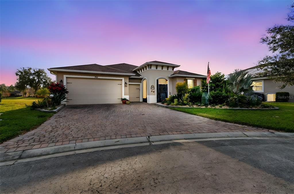 A single-story house with a paved driveway, a three-car garage, and a landscaped front yard — 795 AVIARA LANE, KISSIMMEE, FL