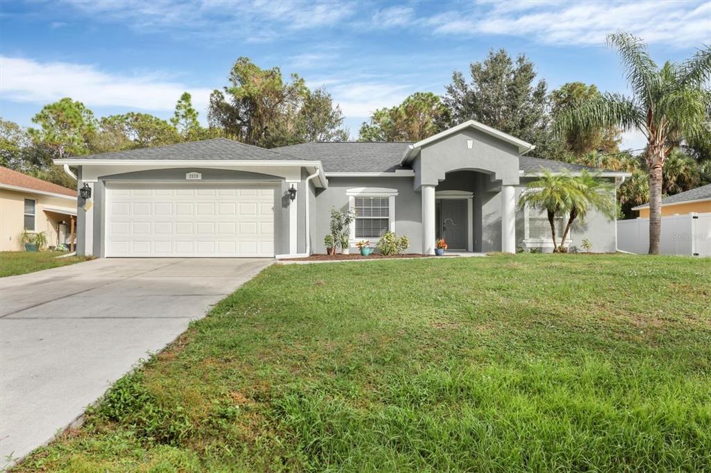 A single-story gray house with a two-car garage and a covered front entryway — 2038 MINCEY TERRACE, NORTH PORT, FL