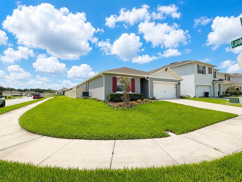 A single-story suburban house with a gray exterior, red shutters, and a two-car garage — 2001 APALACHICOLA LANE, SANFORD, FL