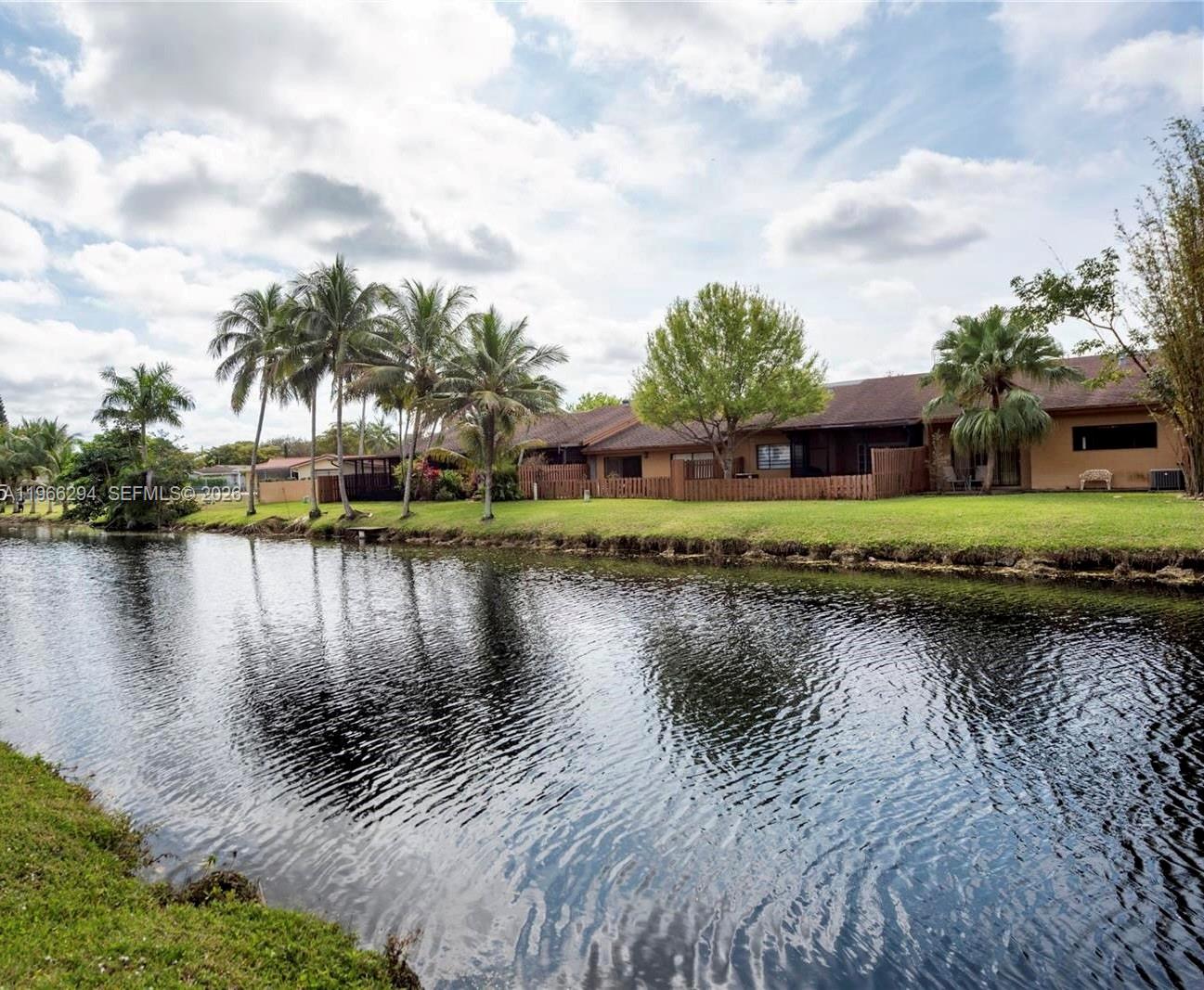 A row of houses with fenced backyards sits along the edge of a canal — 7924 NW 10th St, Plantation FL 33322, PLANTATION, FL