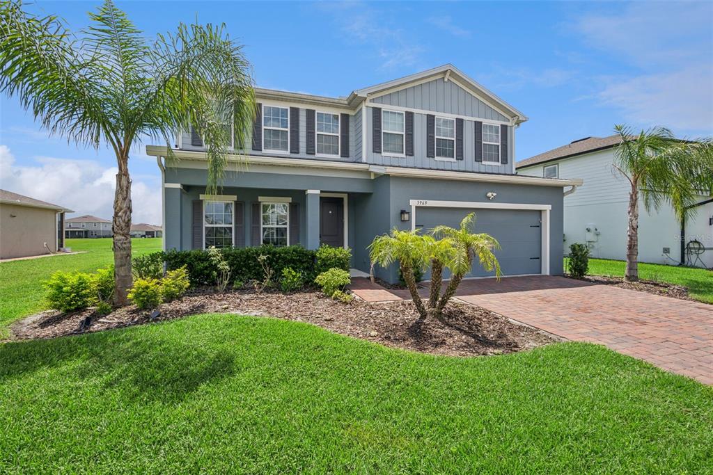 A two-story house with a gray exterior, a paved driveway, and palm trees in front — 3969 CLIPSTONE PLACE, SANFORD, FL