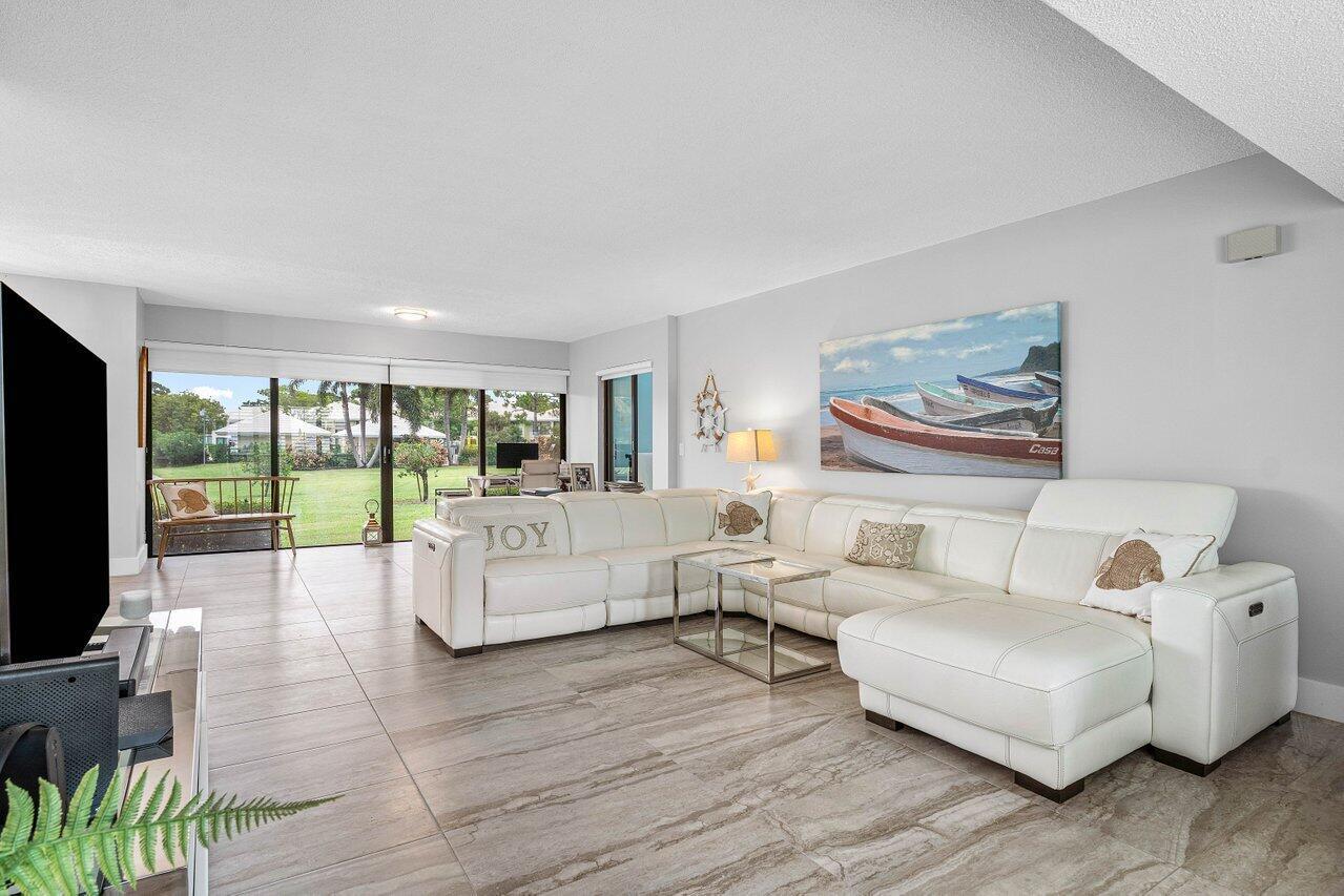 A living room features a white sectional sofa, tile flooring, and a large sliding glass door — 3665 Quail Ridge Drive # B, Boynton Beach FL 33436, BOYNTON BEACH, FL