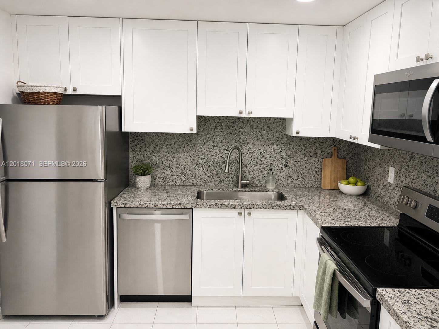 A kitchen features white cabinets, granite countertops, stainless steel appliances, and a tile floor — 1833 S Ocean Dr # 805, Hallandale Beach FL 33009, HALLANDALE BEACH, FL