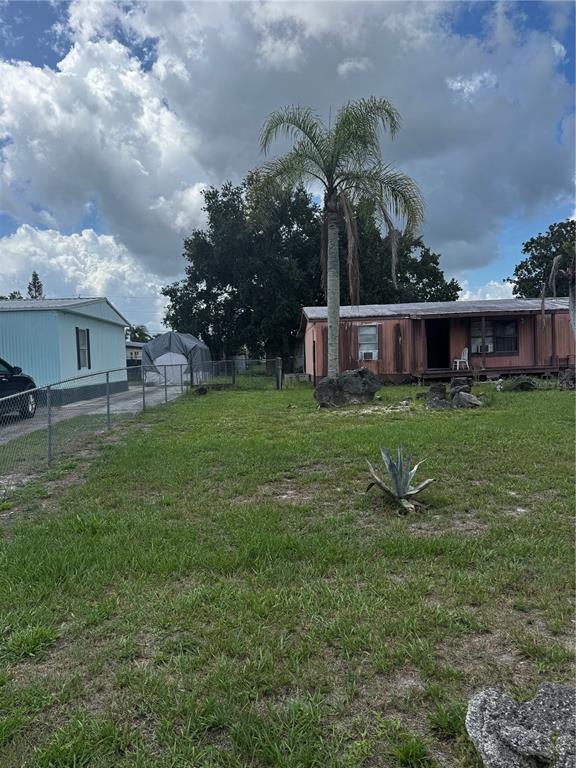 A yard with a palm tree, a small agave plant, and two mobile homes — 373 RONALD STREET, COCOA, FL