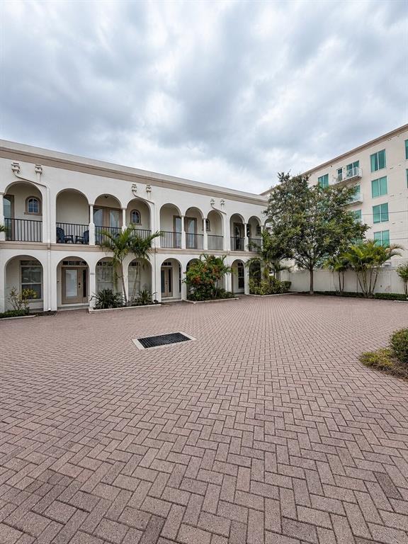 A two-story building with arched walkways and balconies overlooks a brick-paved courtyard — 630 3RD AVENUE S, ST PETERSBURG, FL