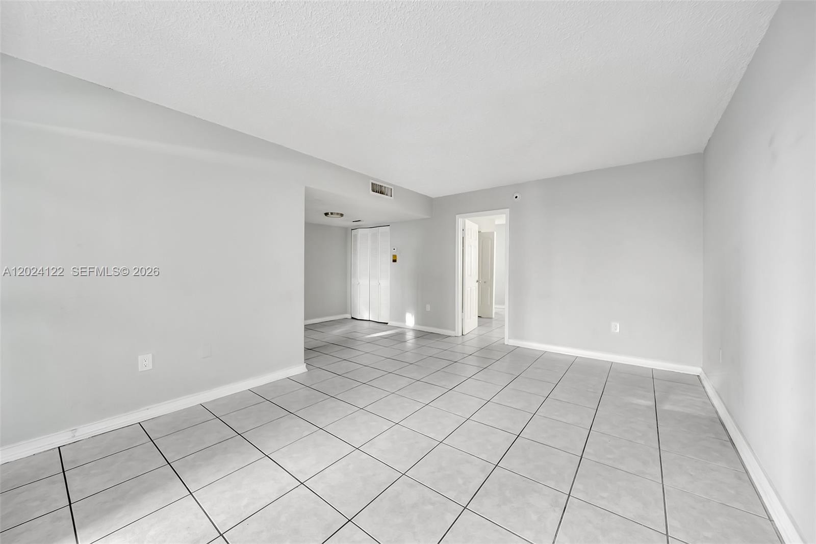 An empty room features light gray walls, white baseboards, and large square floor tiles — 2011 Bay Dr # 12, Miami Beach FL 33141, MIAMI BEACH, FL