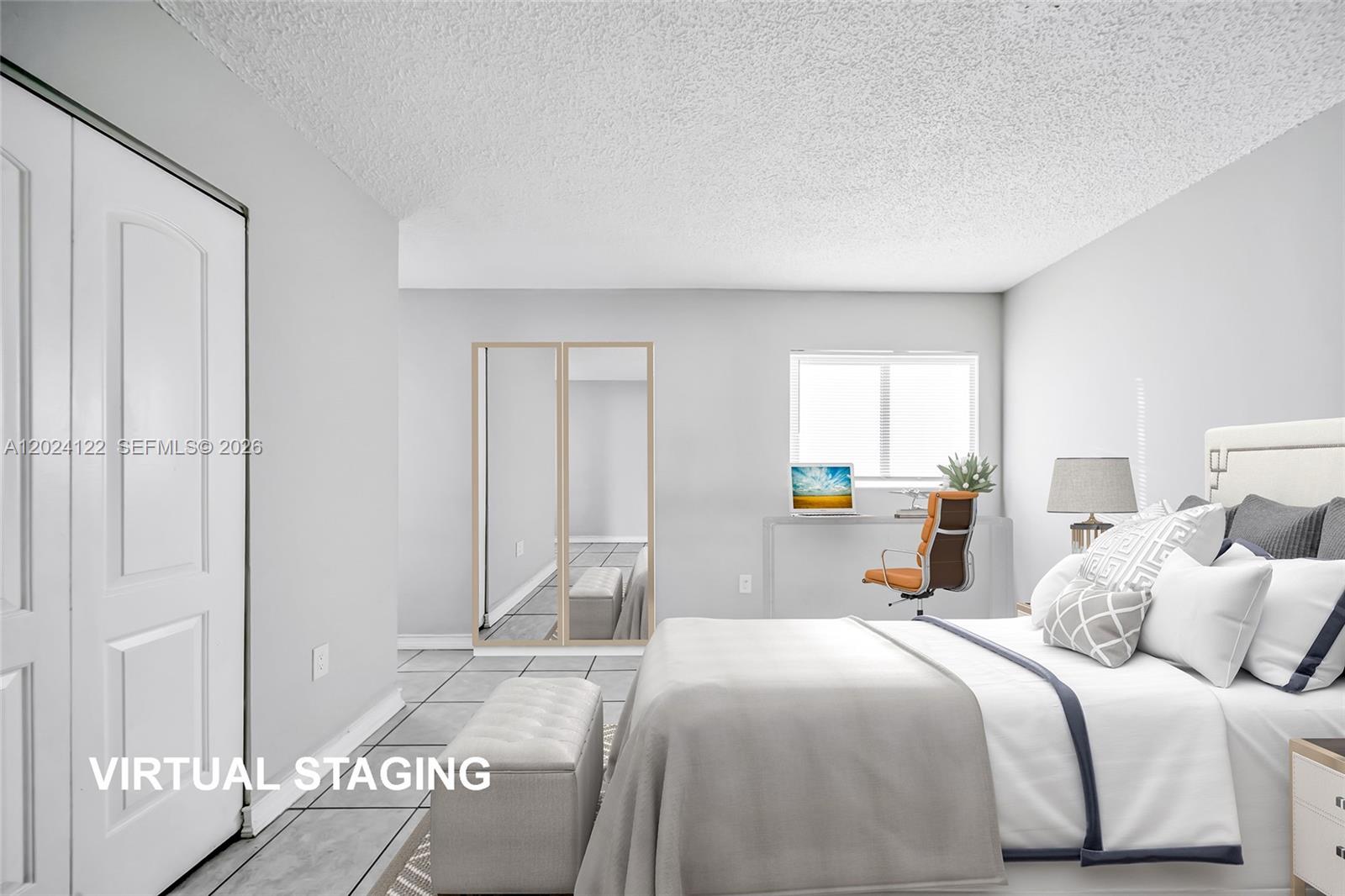 This bedroom features a bed, a desk with a chair, and mirrored closet doors — 2011 Bay Dr # 12, Miami Beach FL 33141, MIAMI BEACH, FL