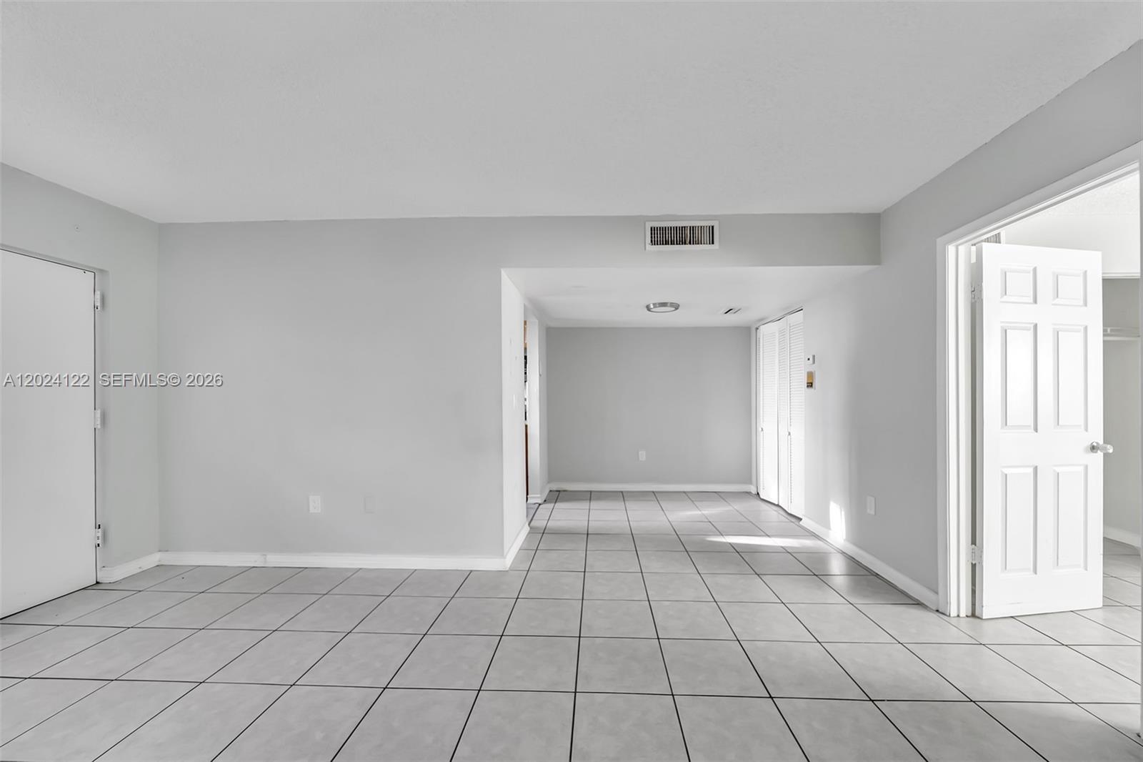 An interior view shows a room with light gray walls, white trim, and tiled flooring — 2011 Bay Dr # 12, Miami Beach FL 33141, MIAMI BEACH, FL