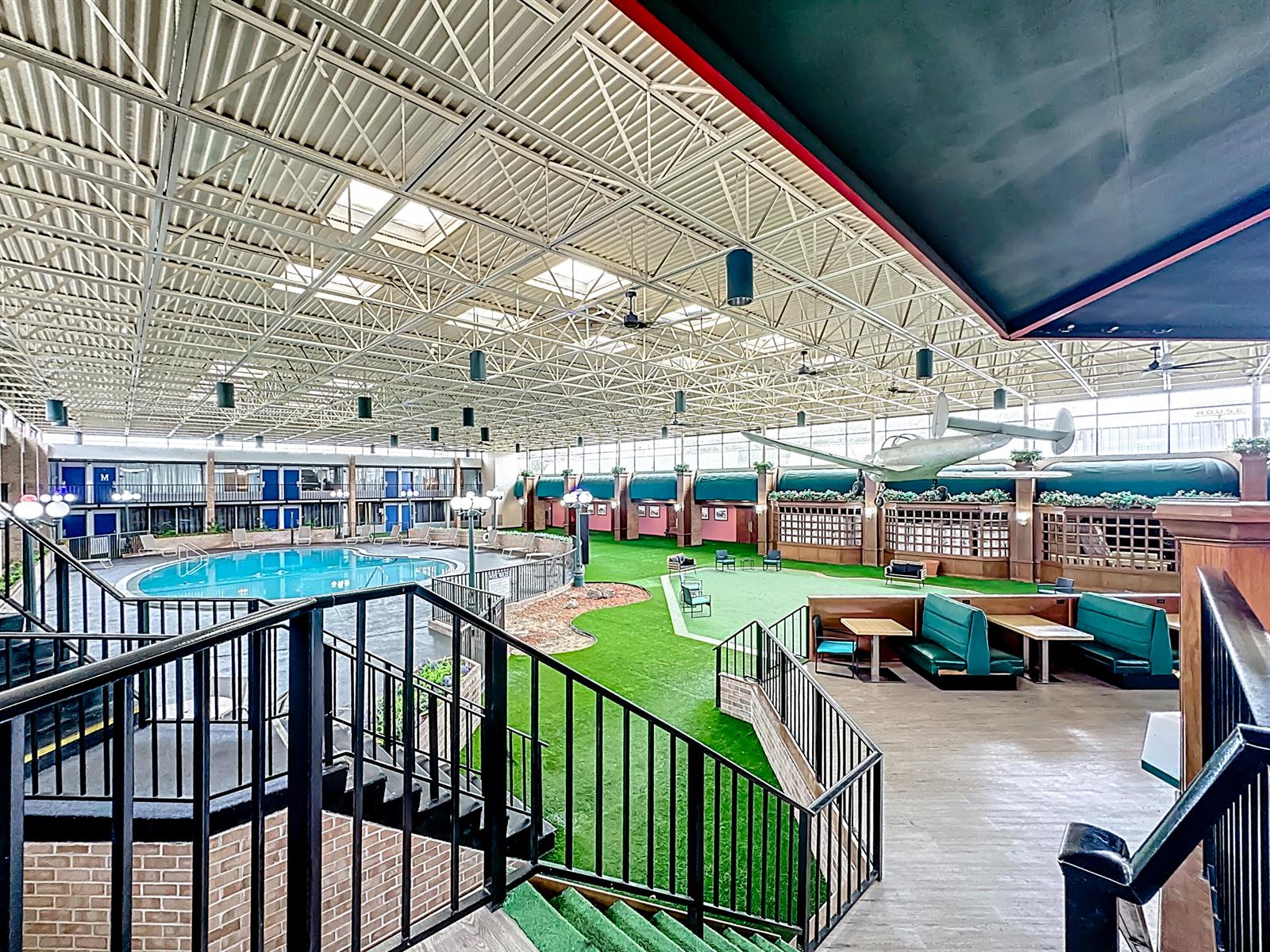 An indoor atrium features a swimming pool, artificial turf, dining booths, and a suspended airplane model — 910 Suemac Road, Jacksonville FL 32254, JACKSONVILLE, FL