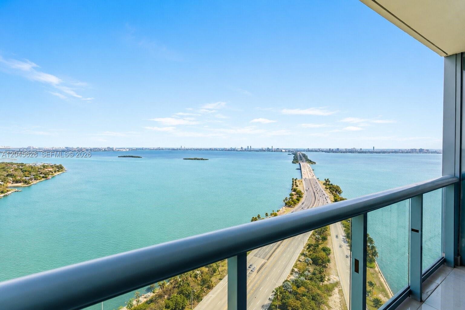 A high-rise balcony overlooks a bridge spanning a large body of water — 601 NE 36th St # 3011, Miami FL 33137, MIAMI, FL