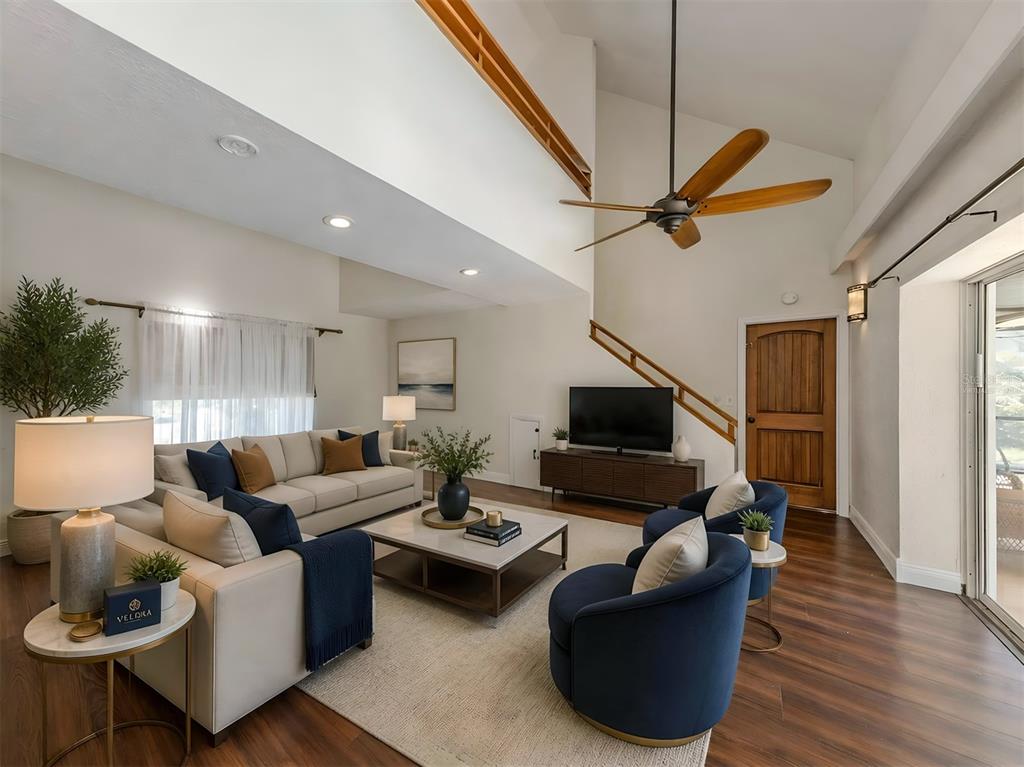A living room features a vaulted ceiling, a ceiling fan, a sofa, and two armchairs — 1533 FUNDY ROAD, VENICE, FL