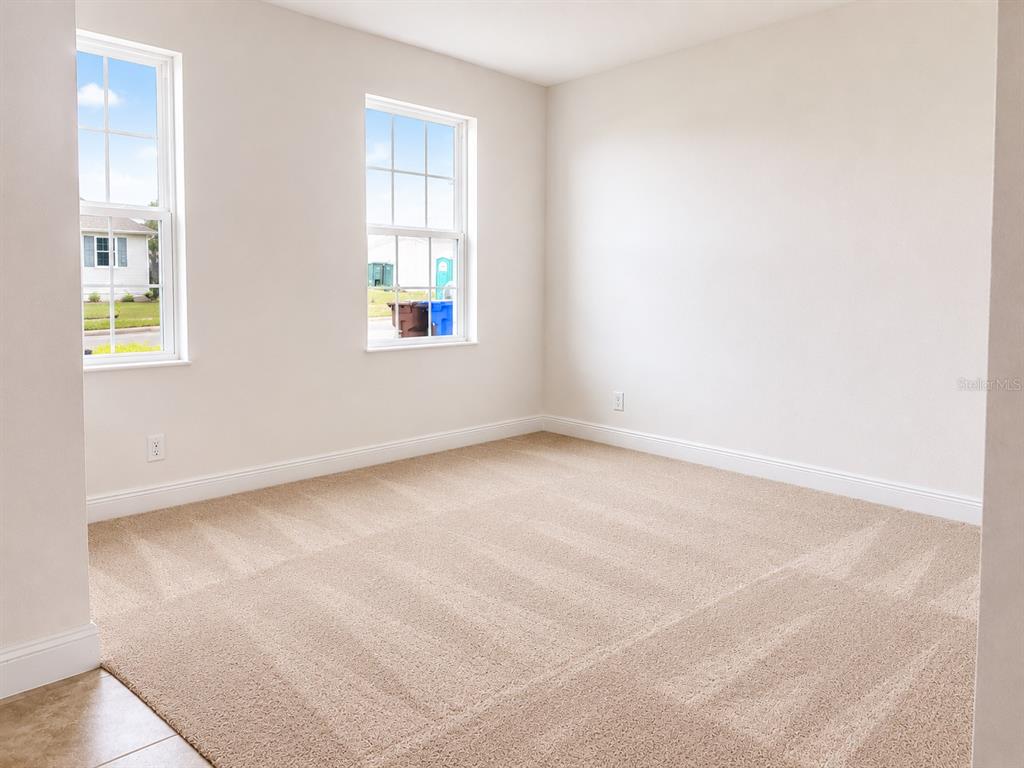 An empty bedroom features beige carpeting, two windows, and light-colored walls — 4932 OLIVIA COURT, ST CLOUD, FL