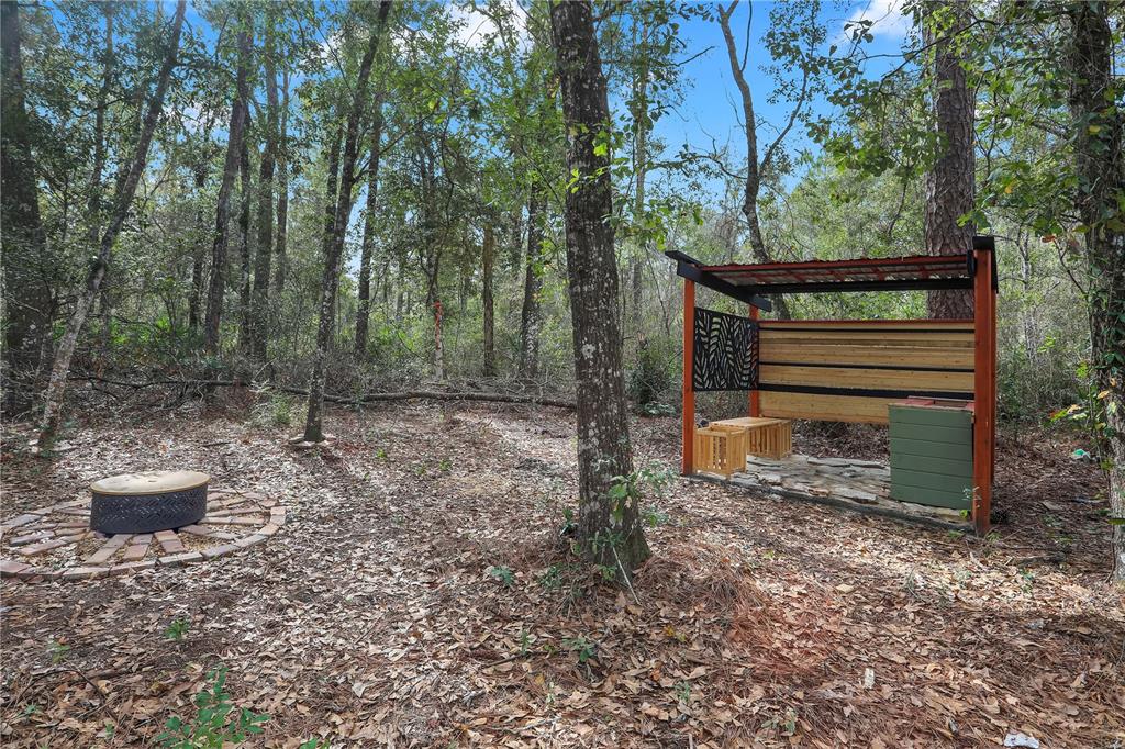 A wooded outdoor area features a fire pit and a covered wooden seating structure — 00 SE 929TH STREET, OLD TOWN, FL