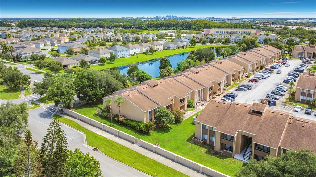 An aerial view shows multi-story apartment buildings, a small pond, and a parking lot — 5247 VINELAND ROAD UNIT 202, ORLANDO, FL