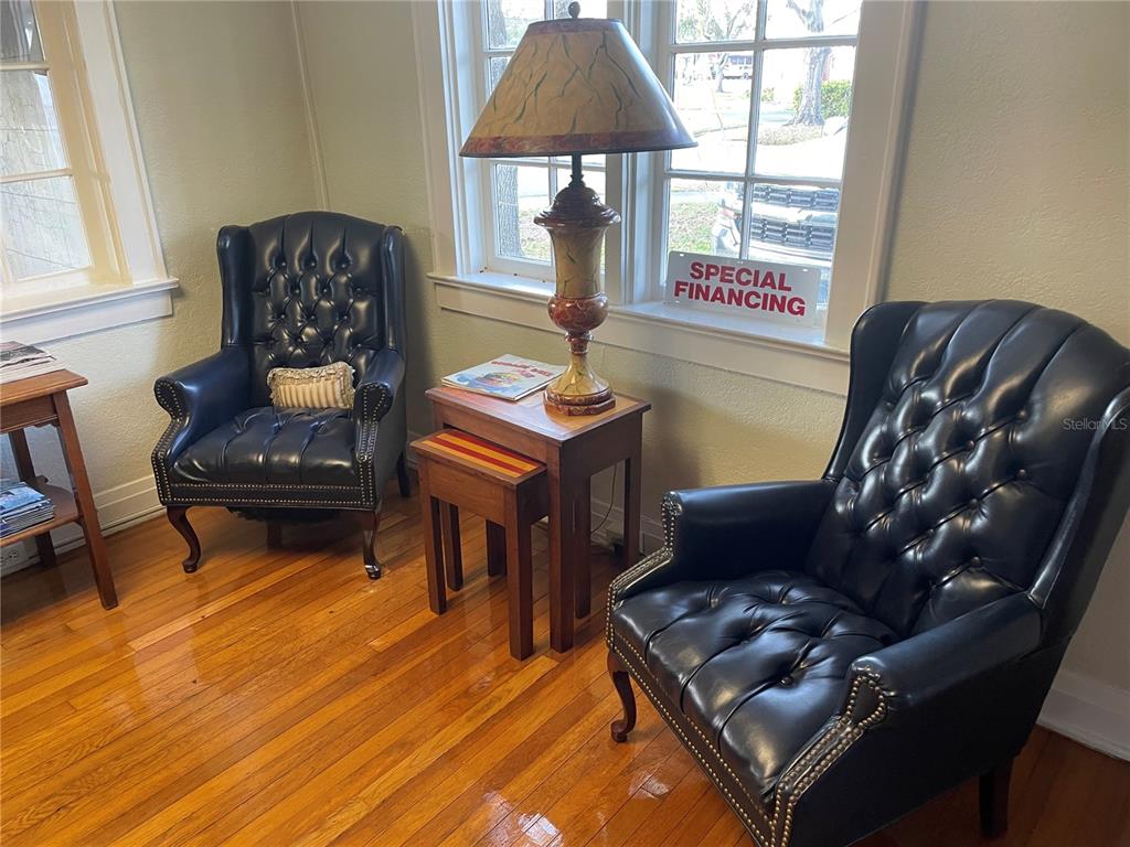 Two dark leather tufted armchairs sit on hardwood floors next to a lamp-topped side table — 210 WOODWARD STREET, LAKELAND, FL