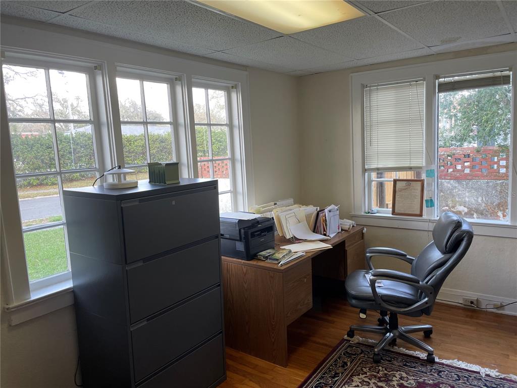 A home office features a wooden desk, a filing cabinet, and windows overlooking a yard — 210 WOODWARD STREET, LAKELAND, FL
