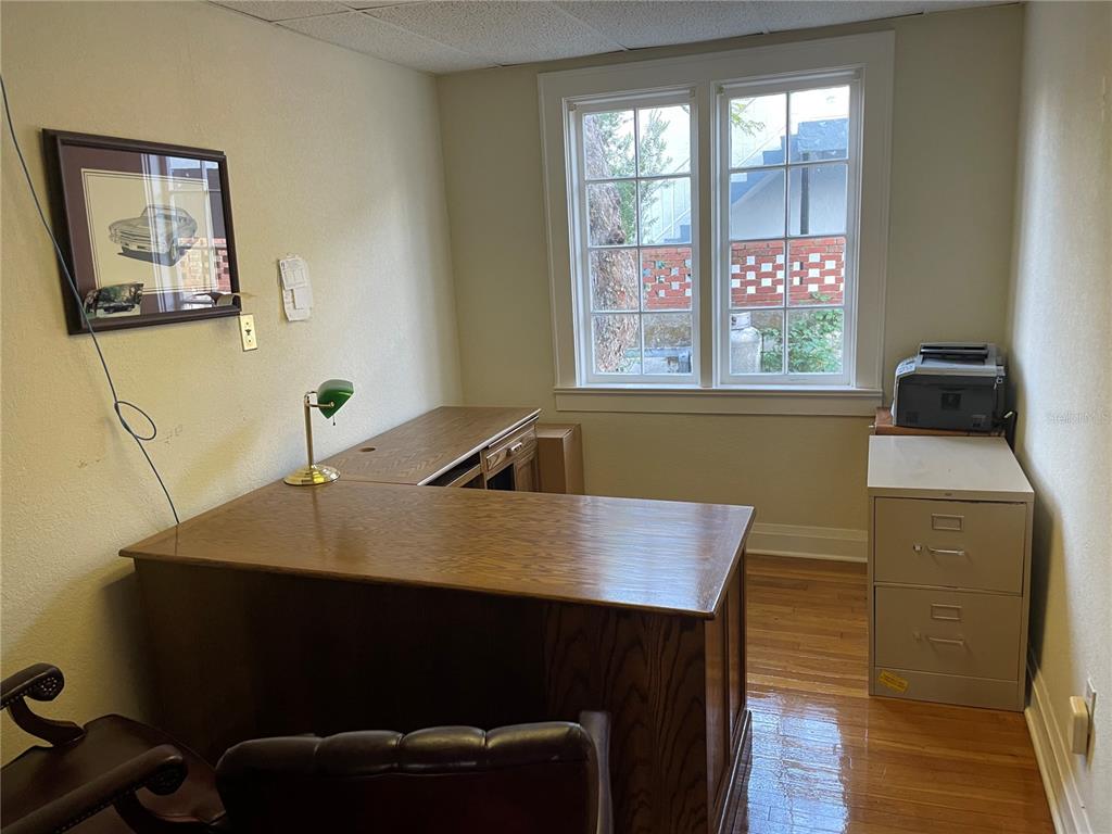 A home office features a wooden L-shaped desk, a filing cabinet, and a window — 210 WOODWARD STREET, LAKELAND, FL