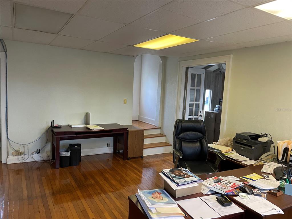 An office space features hardwood floors, a drop ceiling, two desks, and a small staircase — 210 WOODWARD STREET, LAKELAND, FL