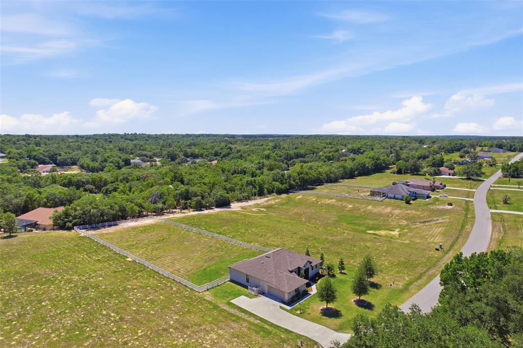 An aerial view shows a single-story house with a fenced yard in a rural area — 1381 N SPEND A BUCK DRIVE, HERNANDO, FL