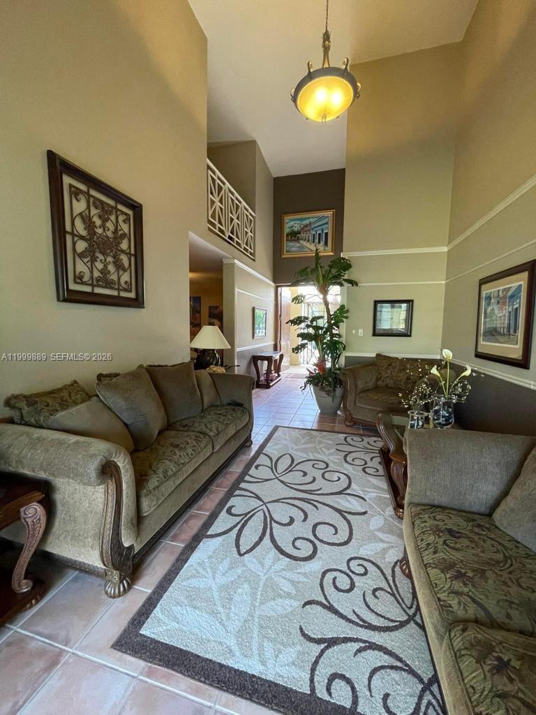 A living room features two sofas, a patterned area rug, and high ceilings — 6690 Cond Royal Palm # G102, PR 00692, PR