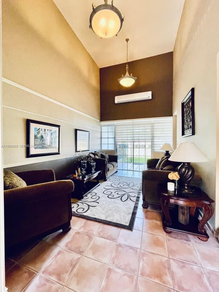 A living room with high ceilings, tile floors, and a sliding glass door to a patio — 6690 Cond Royal Palm # G102, PR 00692, PR