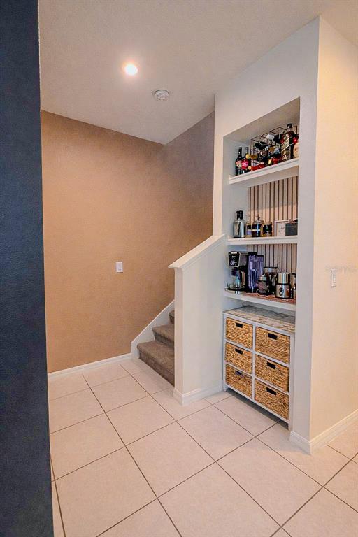 A tiled entryway features a staircase and a built-in shelving unit with a coffee station — 1776 FULFILLMENT DRIVE, KISSIMMEE, FL