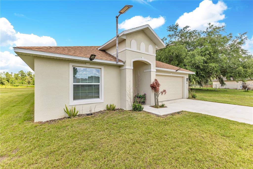 A single-story house with a beige stucco exterior, a brown shingled roof, and a garage — 723 ROBIN COURT, KISSIMMEE, FL