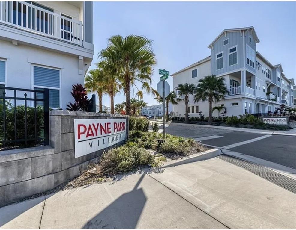 A street-level view of the Payne Park Village entrance sign with multi-story residential buildings nearby — 2317 LINDSTROM STREET, SARASOTA, FL