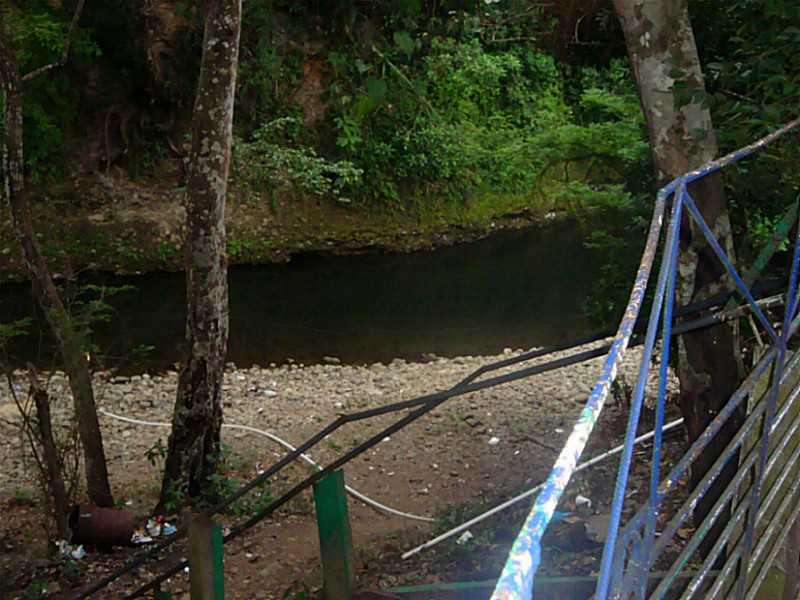 A view of a small stream flowing past a rocky bank near a metal railing — David, SAN PABLO VIEJO, 00000, FL