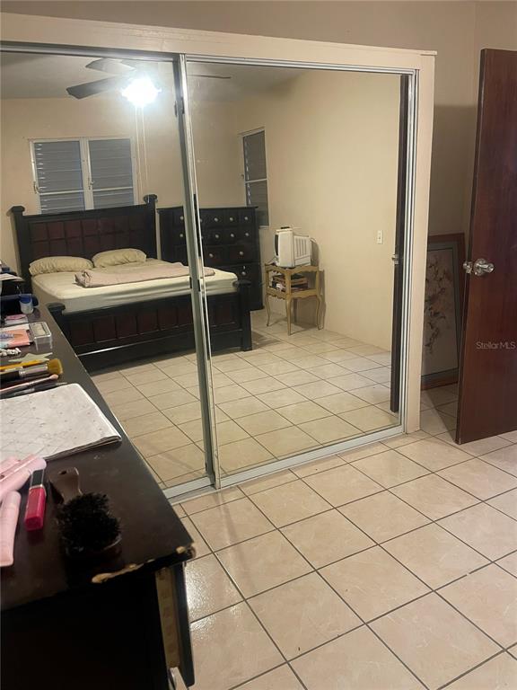 A bedroom featuring a dark wood bed frame, tiled floors, and large mirrored closet doors — Lot 3 CALLE 3, GUANICA, PR