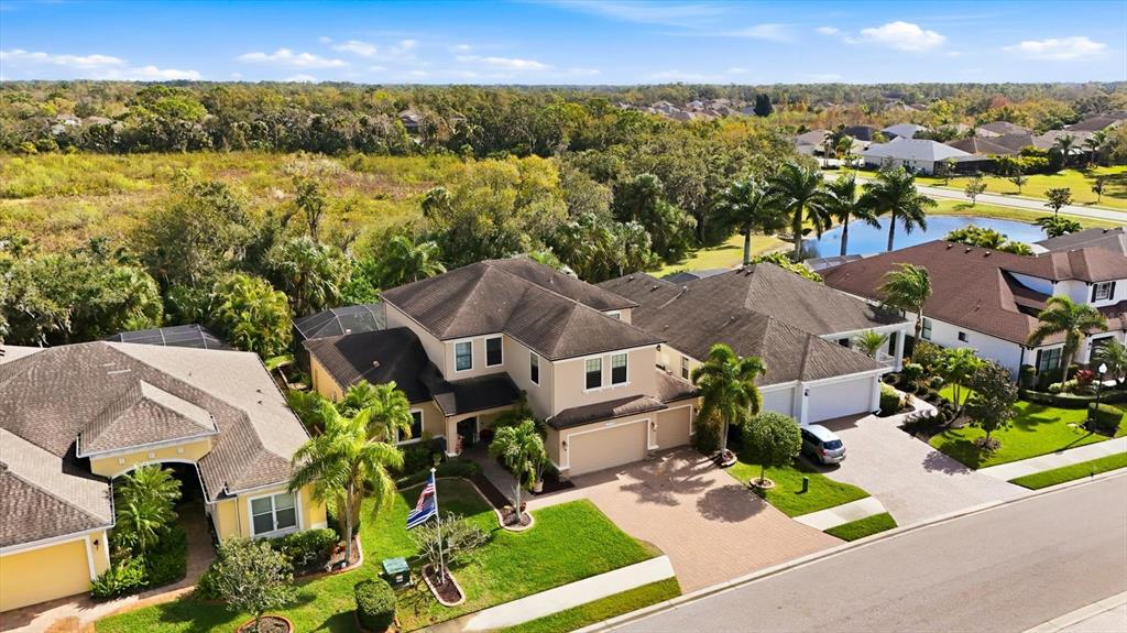 An aerial view shows a two-story suburban house with a paved driveway and palm trees — 707 DOGWOOD RUN, BRADENTON, FL