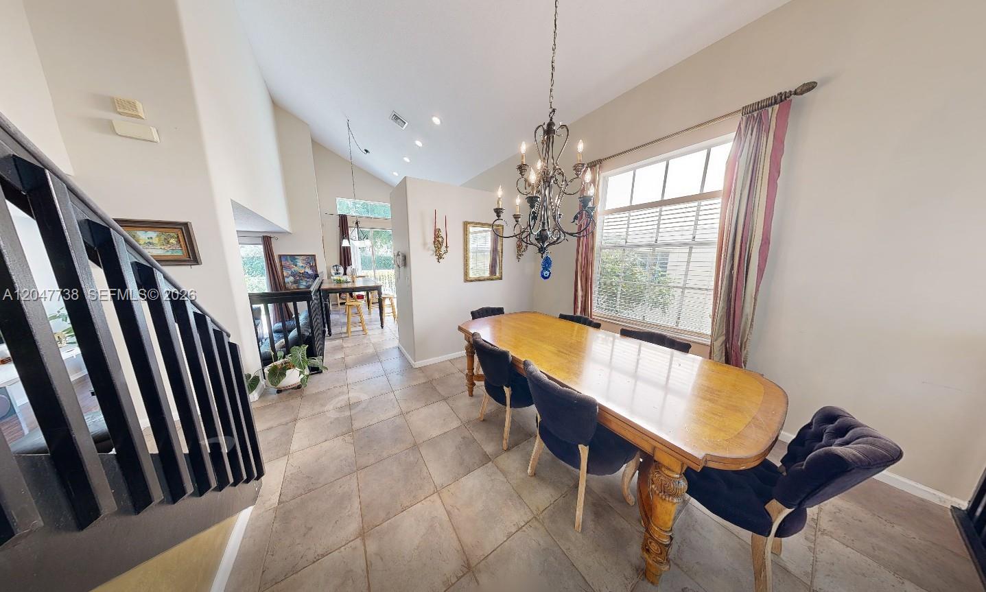 A dining room features a large wooden table, dark chairs, and a metal chandelier — 9640 Wyeth Ct, Wellington FL 33414, WELLINGTON, FL
