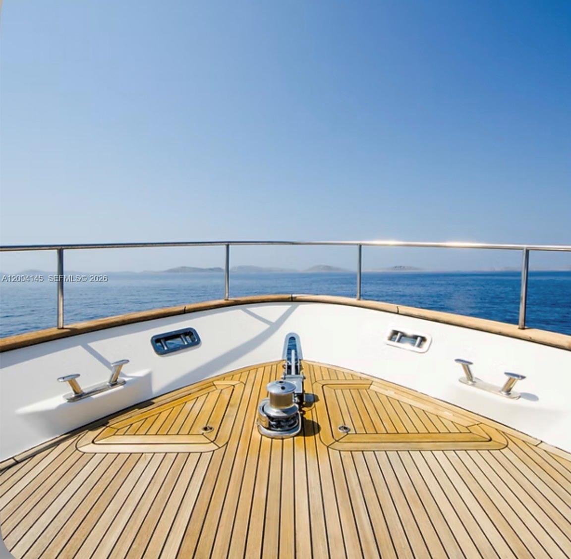 The bow of a yacht features a teak deck, stainless steel railing, and an anchor windlass — 555 NW South River Dr # 728, Miami FL 33136, MIAMI, FL