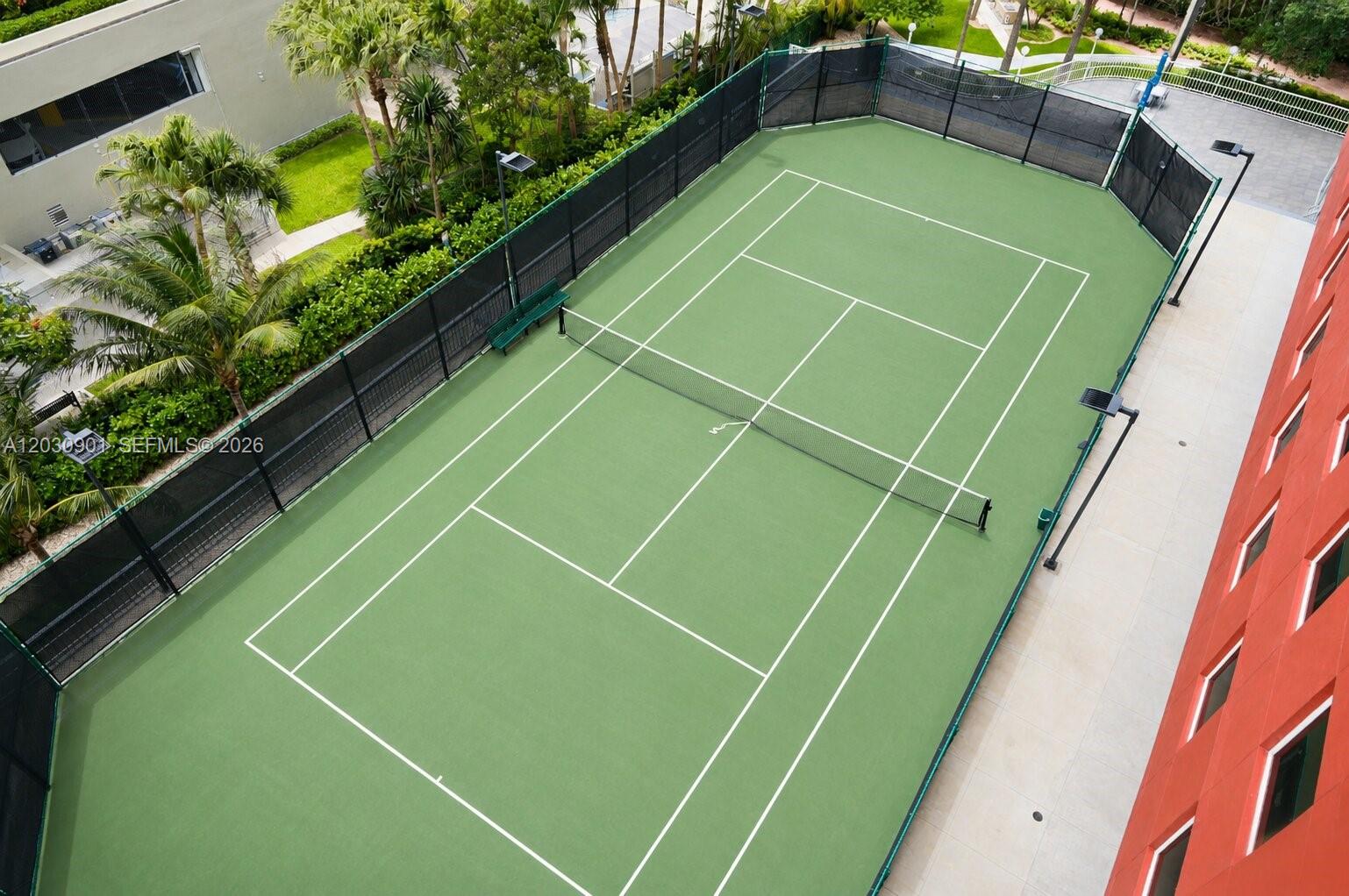 An aerial view shows a green tennis court enclosed by a black fence — 1627 Brickell Ave # 1005, Miami FL 33129, MIAMI, FL