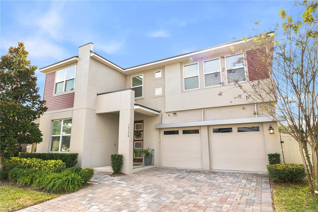 A two-story house with a stucco exterior, a two-car garage, and a paved driveway — 16394 TALIESIN STREET, WINTER GARDEN, FL