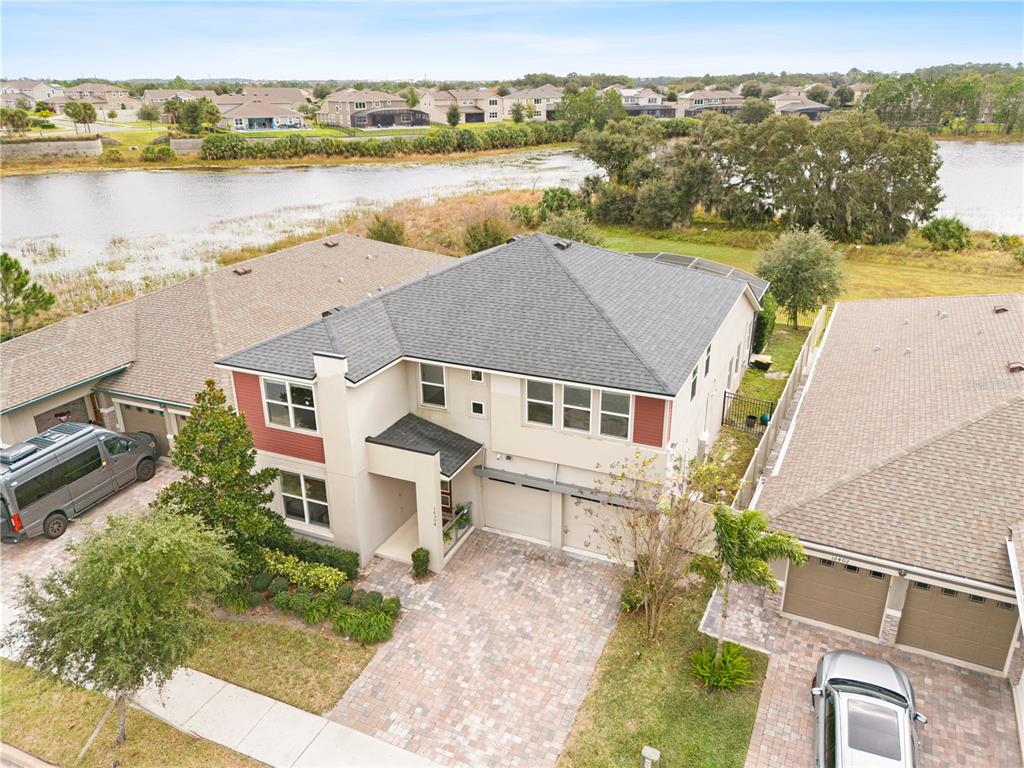 An aerial view shows a two-story house with a gray roof, tan siding, and a driveway — 16394 TALIESIN STREET, WINTER GARDEN, FL