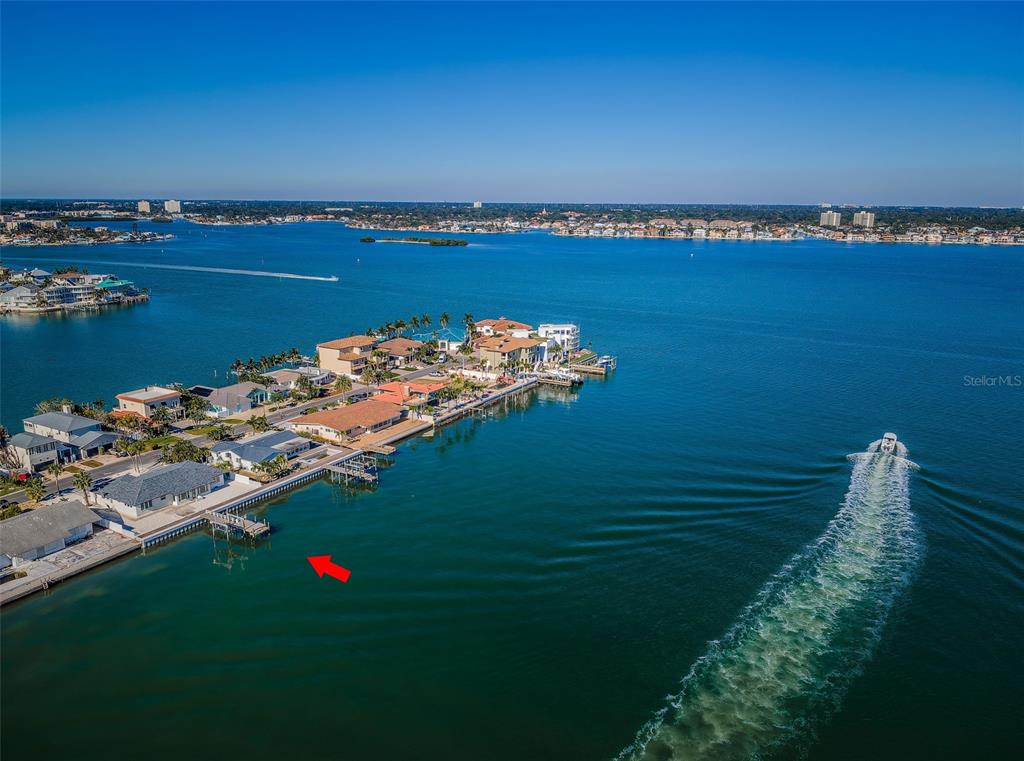 An aerial view shows waterfront homes along a peninsula with a boat dock and boat — 510 55TH AVENUE, ST PETE BEACH, FL