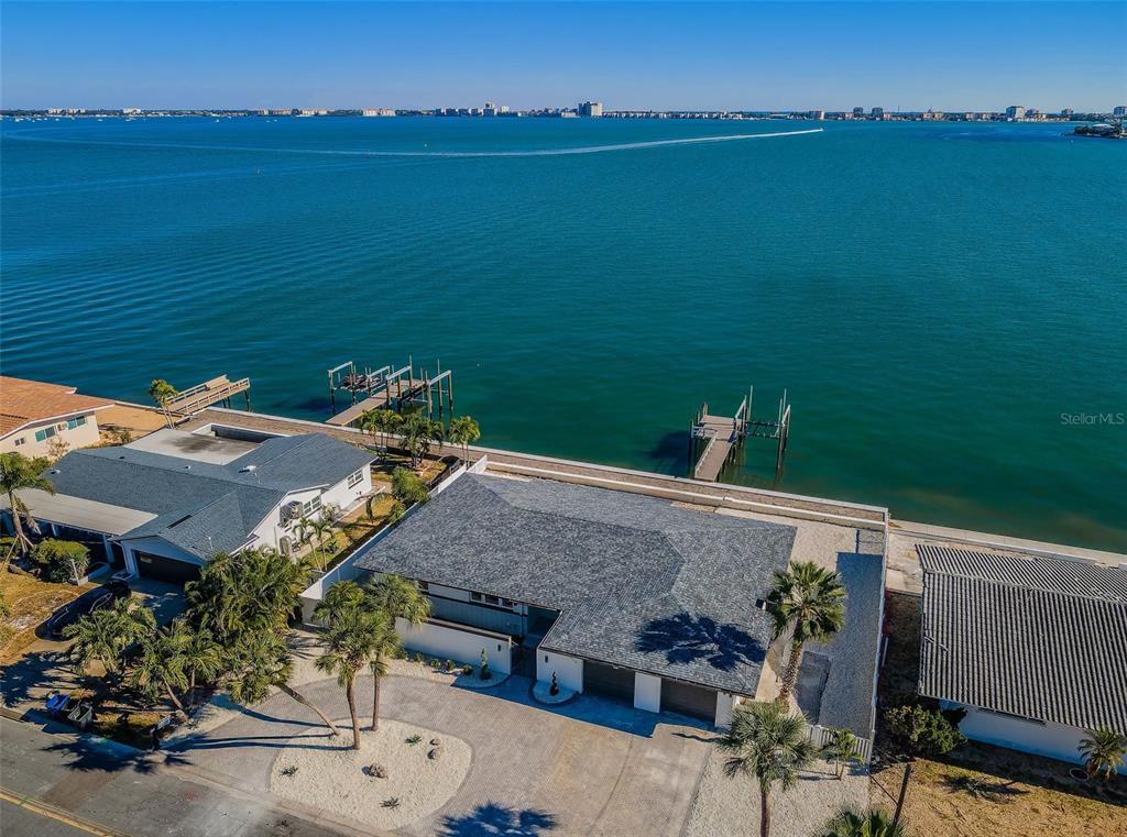 An aerial view shows a waterfront house with a gray roof and a private dock — 510 55TH AVENUE, ST PETE BEACH, FL