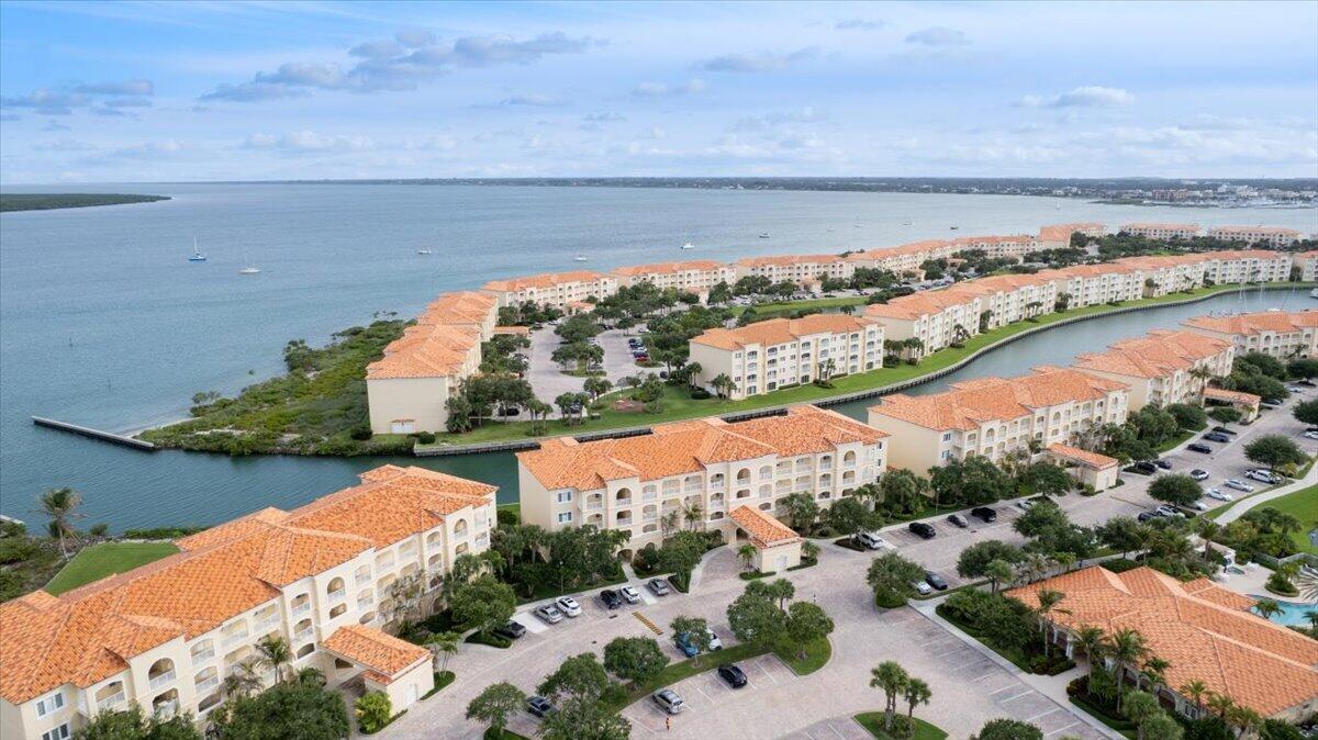 An aerial view of a waterfront residential complex with terracotta-tiled roofs and surrounding parking lots — 5 E Harbour Isle Dr Drive E # 103, Fort Pierce FL 34949, FORT PIERCE, FL